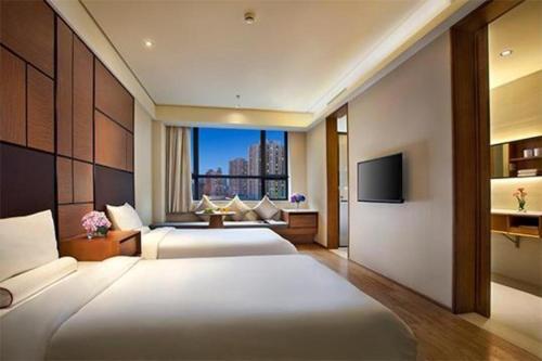 pokój hotelowy z 2 łóżkami i telewizorem w obiekcie JI Hotel Lanzhou Railway Station w mieście Lanzhou