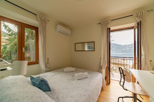 1 dormitorio con 2 camas y ventana grande en Garda Doma, en Brenzone sul Garda