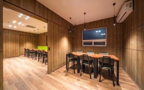 a conference room with tables and chairs and a flat screen tv at Hotel New Castle in Incheon