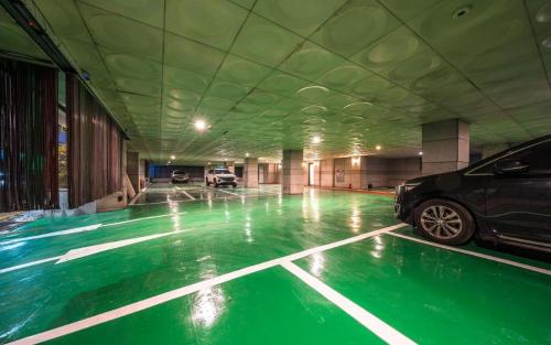 un'auto parcheggiata in un parcheggio con vernice verde di Hotel New Castle a Incheon