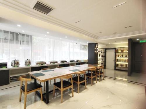 une grande salle à manger avec une grande table et des chaises dans l'établissement GreenTree Inn Shenyang Huanggu District Union Building, à Shenyang