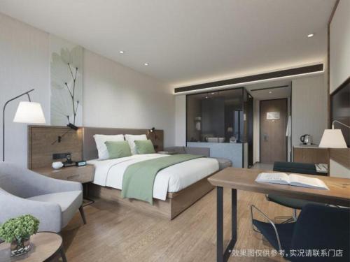 1 dormitorio con 1 cama, escritorio y 1 habitación en GreenTree Inn Shangrao Wuyishan Avenue Meide Yinxiang, en Shangrao