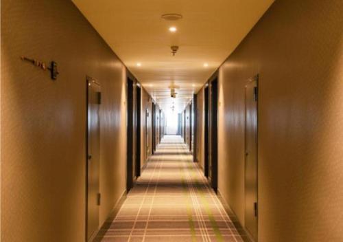 an empty hallway with doors and a long corridor at City Comfort Premier Hotel Wuhan Wangjiawan Hanyang Bus Station Metro Station in Han-yang-hsien