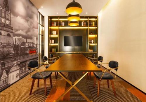 une salle à manger avec une table et une télévision dans l'établissement City Comfort Premier Hotel Wuhan Wangjiawan Hanyang Bus Station Metro Station, à Han-yang-hsien
