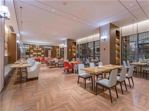 uma sala de jantar com mesas e cadeiras e uma biblioteca em E-Cheng Hotel Dali High-Speed Railway Station Erhai Lake em Dali