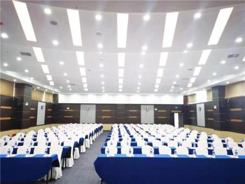 een grote kamer met blauwe en witte tafels en stoelen bij E-Cheng Hotel Dali High-Speed Railway Station Erhai Lake in Dali