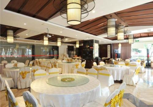 um salão de banquetes com mesas brancas e cadeiras brancas em Borrman Hotel Chengdu Chunxi Road Tianfu Square Metro Station em Chengdu
