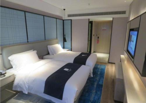pokój hotelowy z 2 łóżkami i telewizorem w obiekcie Echarm Hotel Nanchang Bayi Square Metro Station Wushang MALL w mieście Nanchang