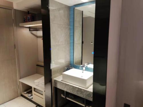 W łazience znajduje się umywalka i lustro. w obiekcie Echarm Hotel Nanchang Bayi Square Metro Station Wushang MALL w mieście Nanchang