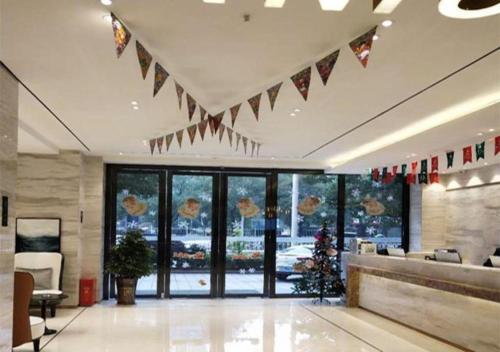 a lobby with a christmas tree and flags on the ceiling at City Comfort Inn Yongzhou Xiaoxiang Bridge Xinhua Bookstore in Guzhuting