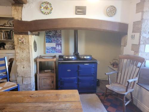 a kitchen with a blue stove and a wooden chair at Prebendal Manor in Nassington