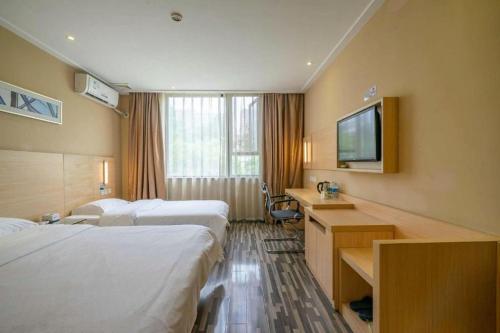 ein Hotelzimmer mit 2 Betten und einem Flachbild-TV in der Unterkunft City Comfort Inn Chengdu Wenjiang University Town in Wenjiang