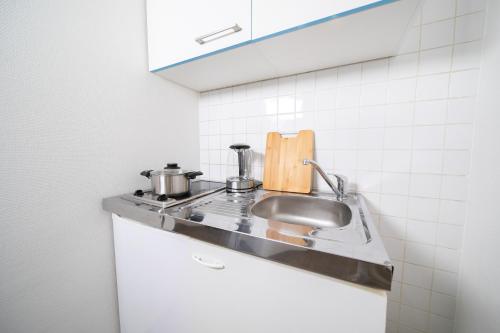 eine Küche mit einer Spüle und einer Arbeitsplatte in der Unterkunft Apartments - Kitchen & More in Düsseldorf