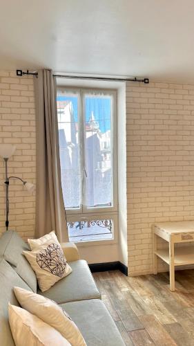 ein Wohnzimmer mit einem Sofa und einem Fenster in der Unterkunft Monroe's studio at the heart of Cannes and beaches in Cannes