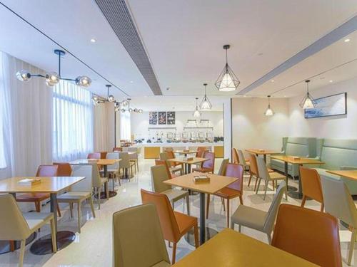 南寧市にあるCity Comfort Inn Nanning Keyuan Avenue Metro Stationのテーブルと椅子が備わるレストラン