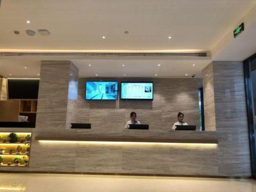 two women sitting in a lobby with their laptops at City Comfort Inn Kunshan High-speed Railway Station Renmin Road in Kunshan