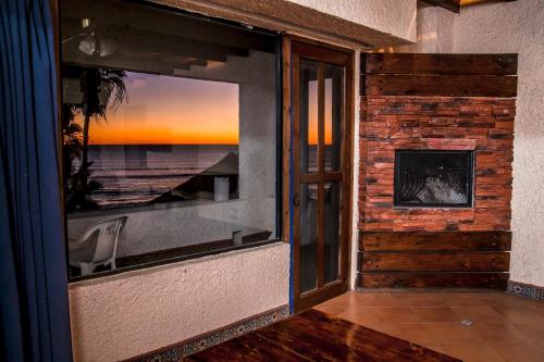 a room with a large window with a fireplace at Las Rocas Resort & Spa in Rosarito