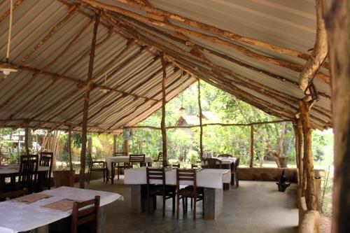 a dining room with tables and chairs in a tent at Eagles Wing's GuestHouse in Habarana