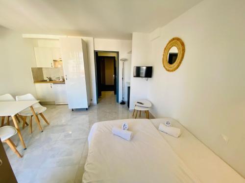 une chambre blanche avec un lit, une table et des chaises dans l'établissement Résidence Graziella Studio 424, à Juan-les-Pins