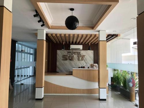 um lobby com um balcão com um sinal que lê a sua sopa em HOTEL SG17 em Tuban