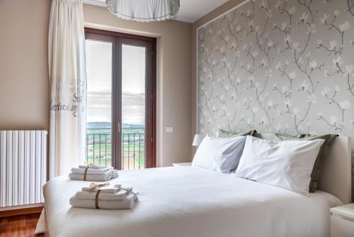 een slaapkamer met een groot wit bed en een raam bij CASA CON VISTA in Potenza Picena