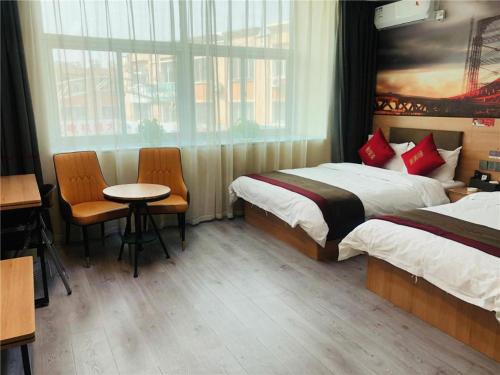 Thank Inn Hotel Inner Mongolia Baotou Donghe Haode Trade Plaza tesisinde bir odada yatak veya yataklar