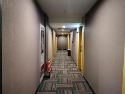 a hallway with a long hallway with a carpet at Thank Inn Hotel Jiangsu Wuxi High-Tech Zone Ruigang Pedestrian Street in Daqiangmen