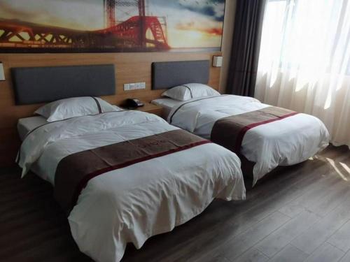 2 bedden in een hotelkamer naast een raam bij Thank Inn Hotel Jiangsu Wuxi High-Tech Zone Ruigang Pedestrian Street in Daqiangmen