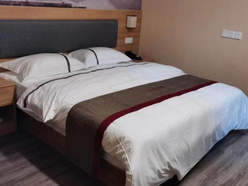 מיטה או מיטות בחדר ב-Thank Inn Hotel Jiangsu Wuxi High-Tech Zone Ruigang Pedestrian Street