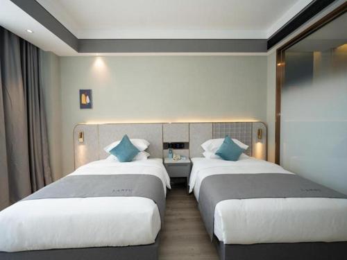 Postel nebo postele na pokoji v ubytování Lano Hotel Anhui Huainan Tianjia'an Banshan Jiayuan