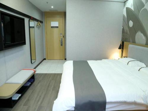 um quarto de hotel com uma cama grande e uma televisão em Thank Inn Hotel Guangxi Qinzhou Lingshan Renhe 