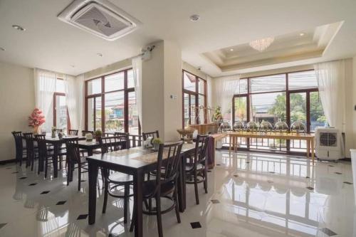 The La-Ngu Boutique في Langu: غرفة طعام مع طاولات وكراسي ونوافذ