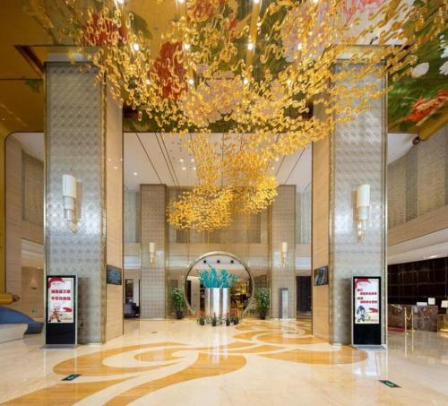 un vestíbulo con una gran lámpara de araña en un edificio en Bairun Zhenjiang International Hotel en Zhenjiang