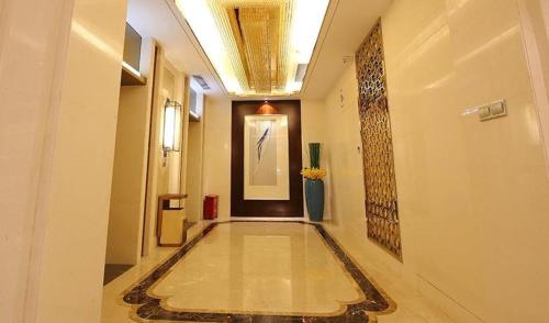 a hallway with a tile floor in a building at Xingtai Yuehai Hotel in Haikou