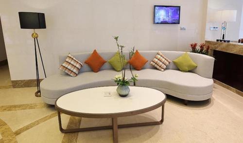 a living room with a couch and a table at Xingtai Yuehai Hotel in Haikou