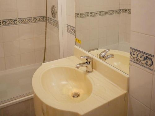 a white bathroom with a sink and a tub at Gresham Hotel in London