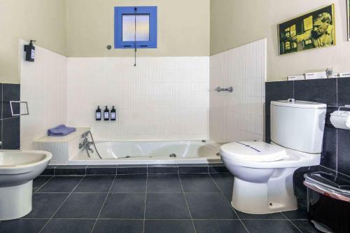 a bathroom with a tub and a toilet and a sink at Hotel Utopía in Benalup Casas Viejas