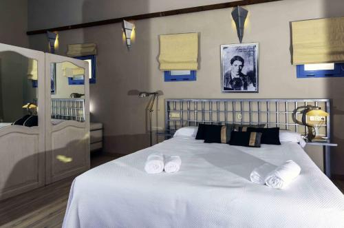 a bedroom with a large white bed with shoes on it at Hotel Utopía in Benalup Casas Viejas