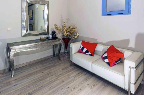a living room with a couch and a table with a mirror at Hotel Utopía in Benalup Casas Viejas