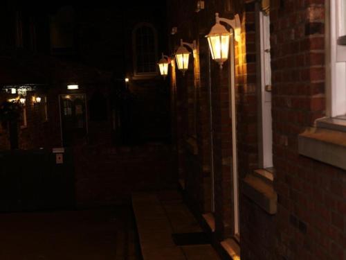 un callejón oscuro con luces en el lateral de un edificio en The Downe Arms en Snaith