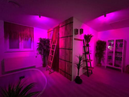 a room with pink lights and plants in it at Relax-Suite in Gelsenkirchen