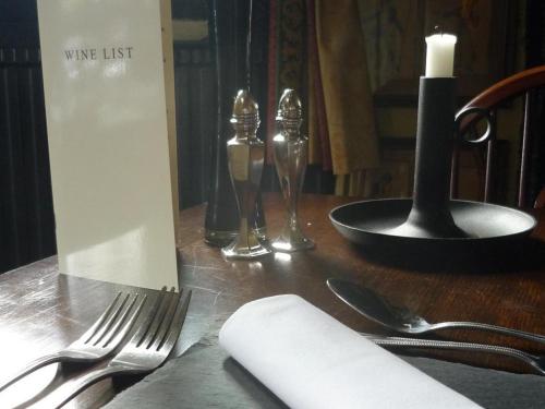 a table with a fork and a candle and a napkin at The Leather Bottle Ltd in Cobham