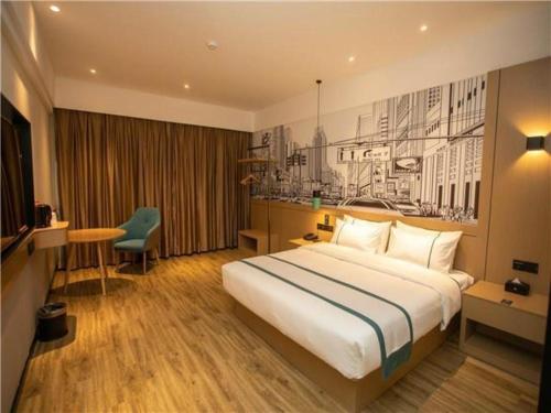 ein Hotelzimmer mit einem großen Bett und einem Schreibtisch in der Unterkunft City Comfort Inn Yangzhou Jiangdu North Limin Road in Jiangdu