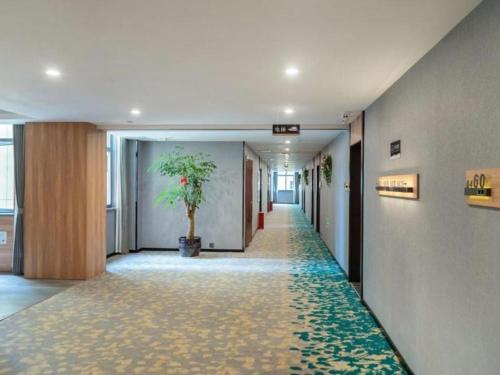 a hallway with a plant in the middle of a building at Green Tree Inn Express Huai'an Huaiyin District Jiangxi Road Normal University in Huai'an
