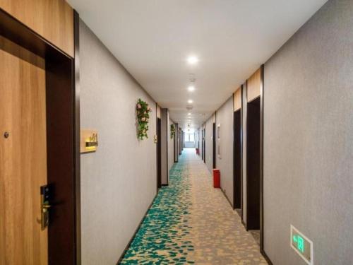 a long hallway with a carpeted aisle in a hospital at Green Tree Inn Express Huai'an Huaiyin District Jiangxi Road Normal University in Huai'an