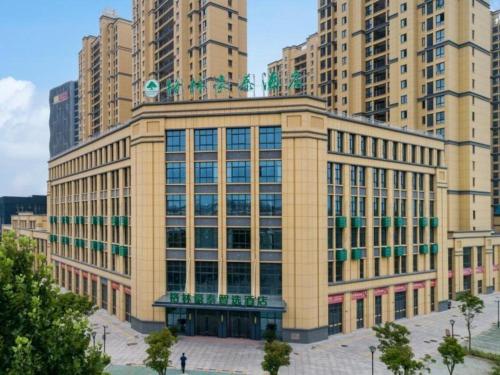 a large building in a city with tall buildings at Green Tree Inn Express Huai'an Huaiyin District Jiangxi Road Normal University in Huai'an