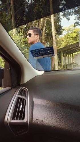 Um homem está sentado num carro com uma etiqueta de carro. em Cinta Sayang-Sky Residence em Sungai Petani