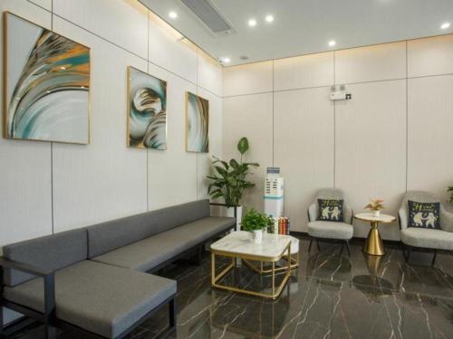 een wachtkamer met een bank en twee stoelen bij Green Tree Inn Express Yulin Chinese Medicine Port in Yulin