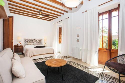 um quarto branco com uma cama, um sofá e uma mesa em Casa Mona Turismo de Interior em Llubí