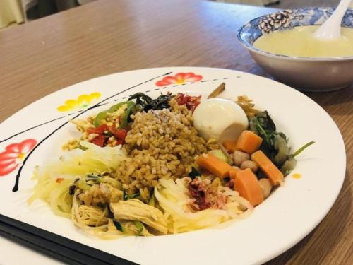 een bord met rijst en groenten op een tafel bij GreenTree Alliance Hotel Tianjin Jinnan District Gegu Stadium in Jinnanqu